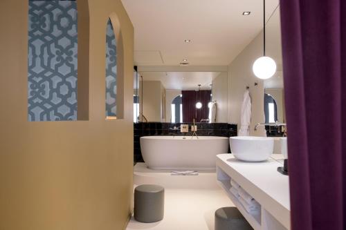里昂MiHotel Tour Rose的一间带大浴缸和水槽的浴室