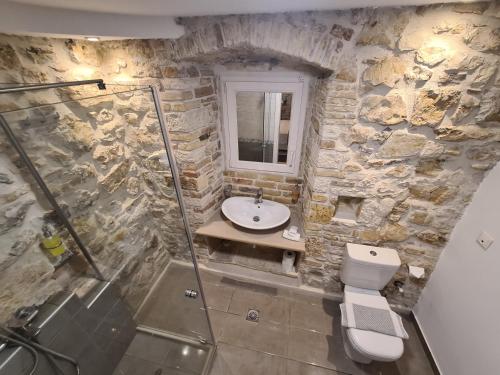 科孚镇NJ Corfu Liston Apartments的石质浴室设有水槽和卫生间