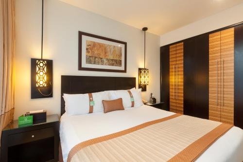 迪拜迪拜阿尔巴沙假日酒店的一间卧室配有一张大床和两盏灯。