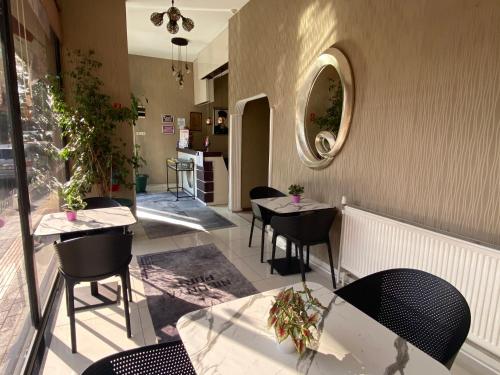 伊斯坦布尔尼康亚港口套房及酒店的餐厅设有桌椅和镜子