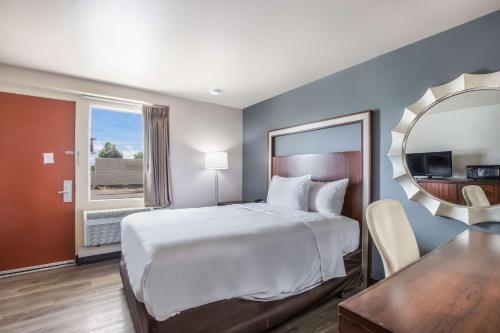尼纳Econo Lodge Neenah的配有一张大床和镜子的酒店客房