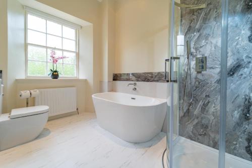 利文斯顿Bankton House的一间带大型白色浴缸和淋浴的浴室