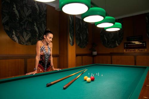 利多迪耶索罗罗莎酒店的站在台球桌旁的女人