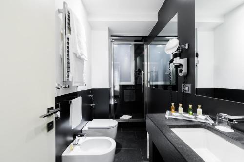 罗马曼奇诺街12号酒店的黑白浴室设有卫生间和水槽