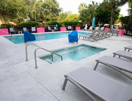 默特尔比奇水族海滩酒店 的一个带椅子和桌子的游泳池