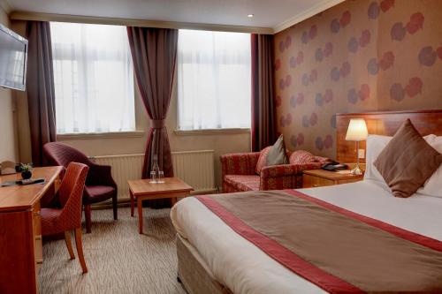 卡莱尔Crown & Mitre Hotel的酒店客房,配有一张床、一张桌子和椅子