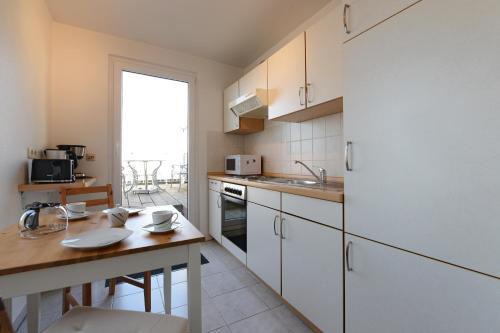 维斯马Fürstenhof Apartment Wismar的厨房配有白色橱柜和木制台面