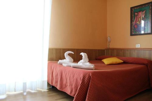 米兰卢伽诺酒店的两个天鹅坐在床上