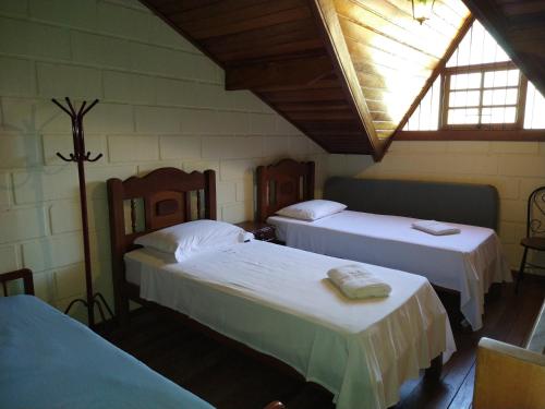 圣安东尼奥-杜皮尼亚尔Chale da Ana的一间卧室设有两张床和窗户。