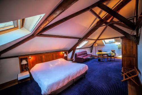 香槟沙隆丹格勒特酒店的阁楼上的卧室配有床和桌子