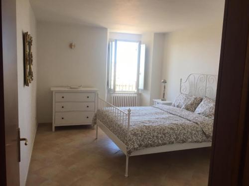 阿西西Residenza La Luce di Assisi的一间卧室配有一张床、一个梳妆台和一扇窗户。