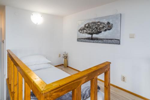 斯普利特Apartment Tomas的墙上有一棵树的房间的一张床位
