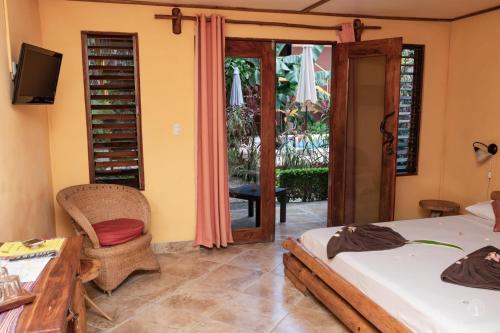 萨玛拉Samara Palm Lodge的一间卧室设有两张床、一张桌子和一个庭院。
