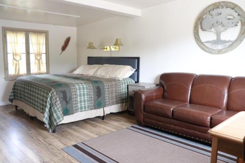 埃斯蒂斯帕克Olympus Lodge的一间卧室配有一张床和一张皮沙发