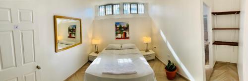 特古西加尔巴帕尔米拉旅馆 的白色的客房配有床和镜子