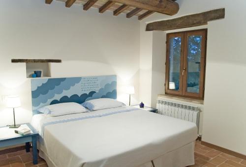 Loro PicenoBorgo Sorbatti的卧室设有一张白色大床和一扇窗户。