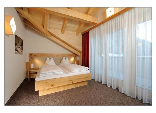 伊施格尔Apart Garni Schadhof的一间卧室设有一张床和一个大窗户