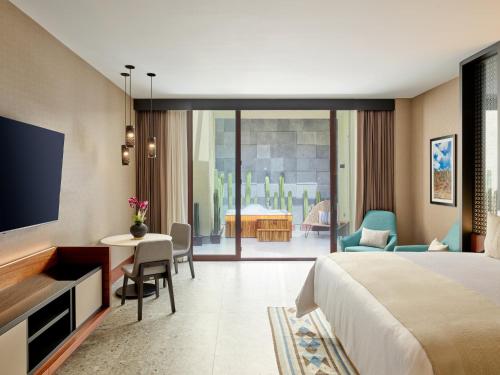 瓦哈卡市Grand Fiesta Americana Oaxaca的酒店客房设有一张床、一张书桌和一台电视机。