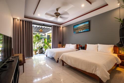 会安hoi an center town的酒店客房设有两张床和电视。
