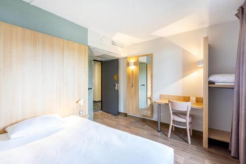 圣锡尔万当茹B&B HOTEL Angers Parc Expos的配有一张床和一张书桌的酒店客房