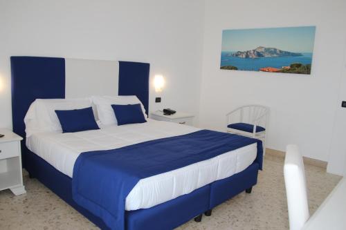 索伦托索伦托尼多酒店的一间卧室配有蓝色和白色床单