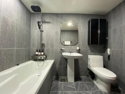 大田贝尼基亚代里姆酒店的浴室配有盥洗盆、卫生间和浴缸。
