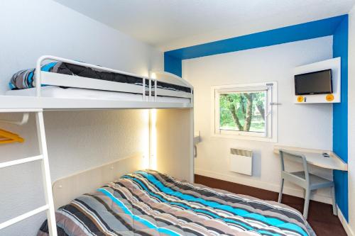 图尔图尔北F1酒店的一间带双层床和书桌的小卧室