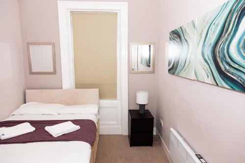 盖茨黑德Tyne Apartments的卧室配有一张床,墙上挂有绘画作品