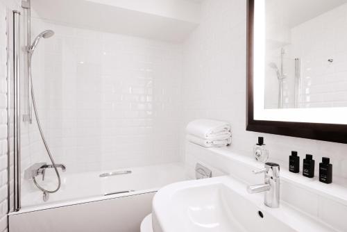 巴黎广场酒店的白色的浴室设有水槽和镜子
