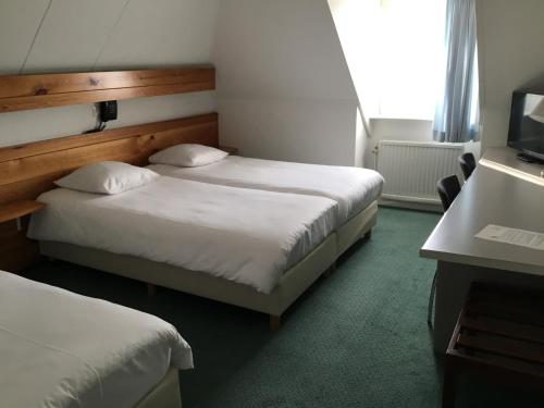 Steensel斯滕赛尔酒店的酒店客房设有两张床和电视。