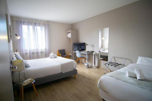 富瓦皮雷酒店的酒店客房配有两张床和一张书桌
