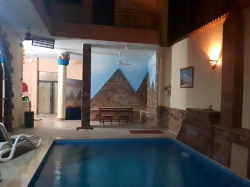 卢克索Pyramids Luxor Hotel & SPA的一个带桌子的房间的大型游泳池