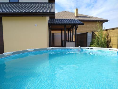 切尔诺莫斯克Дом Дискавери семейный у моря!的一座大蓝色游泳池,位于房子前