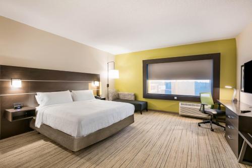 杰克逊维尔Holiday Inn Express & Suites Jacksonville - Town Center, an IHG Hotel的配有一张床和一台平面电视的酒店客房