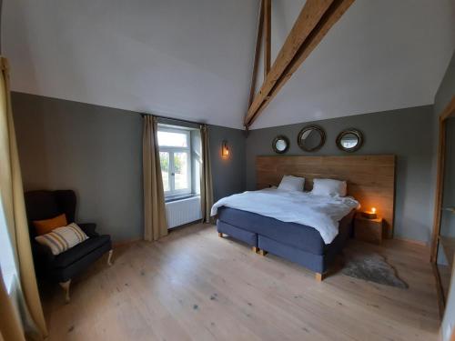 索海尔Cottage in Ardennes - La Maison aux Moineaux - Fays-Famenne的卧室配有床、椅子和窗户。
