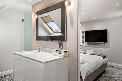 温莎温莎时光酒店的一间带水槽和镜子的浴室以及一张床