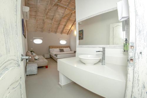 卡塔赫纳Casa Amanzi Hotel Cartagena的一间带水槽的白色浴室和一间客厅