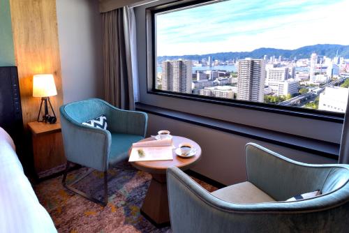 神户科比波特匹亚酒店的一间设有两把椅子、一张桌子和一个窗户的房间