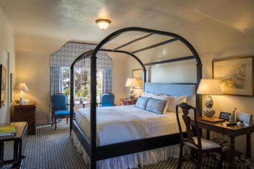 卡梅尔劳伯格卡梅尔瑞莱堡酒店的一间卧室配有一张大床和一张桌子及椅子