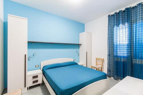 圣维托罗卡波B&B "Perla del Sud"的一间卧室配有一张蓝色床头板的床
