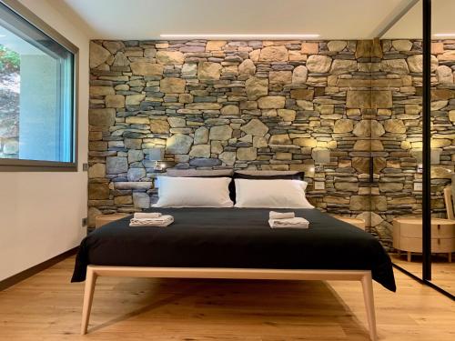 阿夸拉尼亚La Forestale Luxury Ecolodge B&B Primo Piano的一间卧室设有石墙和一张床