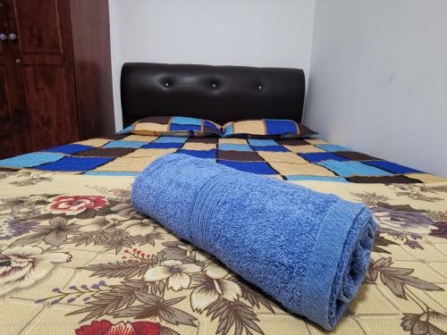 汝来AniS Homestay Nilai USIM KLIA INTI Manipal Nilai 3的床上铺着蓝色的毯子