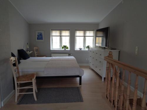 福堡Dejligt lille byhus的一间卧室配有一张床、梳妆台和窗户。