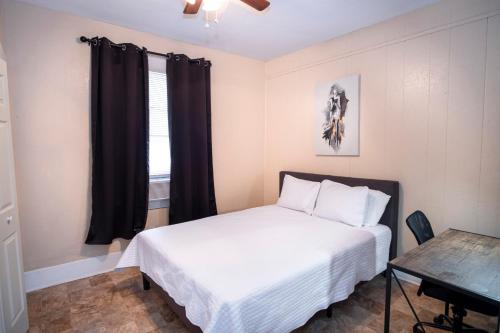 圣安东尼奥Virginia #A Cozy 2BA/1BA near Downtown Sleeps 8的一间卧室配有一张床、一张书桌和一个窗户。