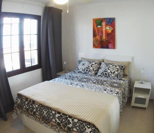 卡勒达德福斯特Castillo Sol Bungalow的卧室配有一张床,墙上挂有绘画作品