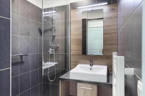 圣艾格夫Résidence Odalys Domaine des Eucalyptus的一间带水槽、淋浴和镜子的浴室