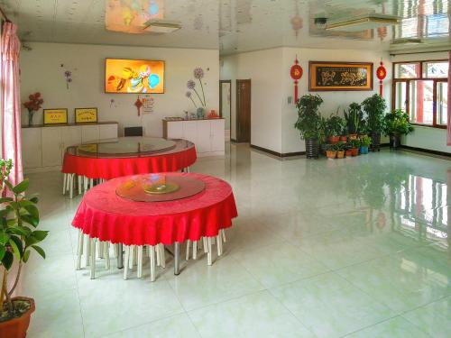 吉林雾凇岛满照凇居客栈的一间房间,设有两张桌子和红色桌布