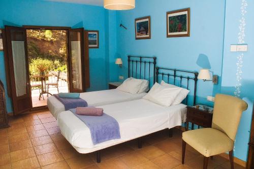 阿拉哈尔Posada San Marcos的蓝色卧室,配有床和椅子