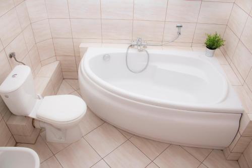 华沙Marymont的浴室配有卫生间、坐浴盆和浴缸。