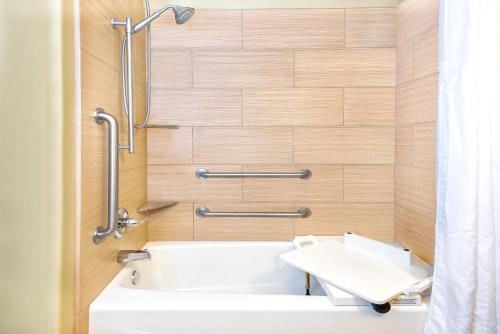莫纳汉斯莫纳汉斯I-20智选假日套房酒店的浴室配有白色浴缸和淋浴。
